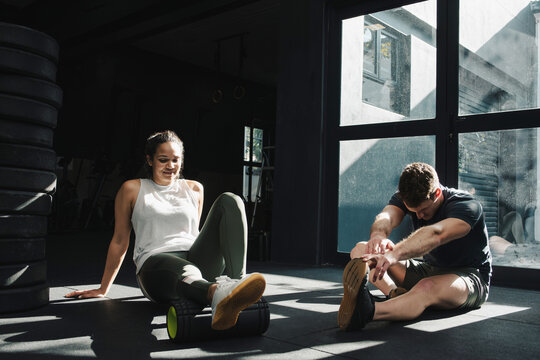 Fitness coach instructing sportswoman during exercise at gym - Powered by Adobe
