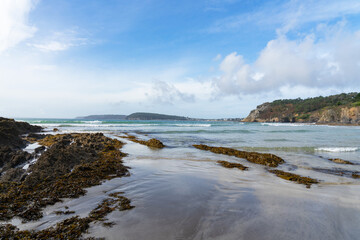 Plage sauvage de la presqu'île de Crozon, joyau breton bordé par la mer d'Iroise, mêlant sable fin, falaises escarpées, sillons rocheux et nature préservée.