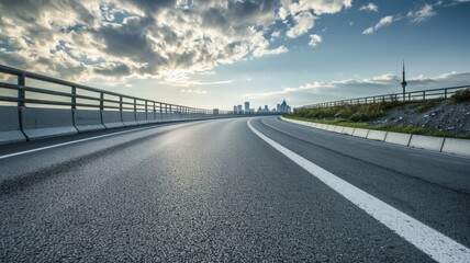 Fototapeta premium curved asphalt highway road and city skyline afternoon light.