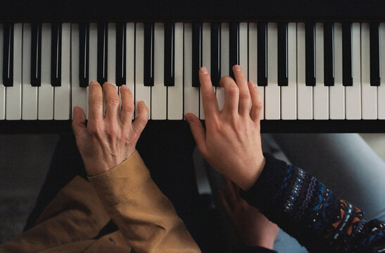 Mother and daughter playing piano together
