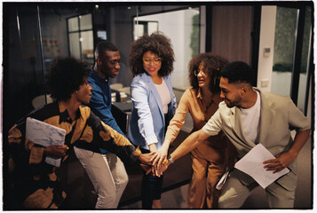 Businesspeople putting hands together in office