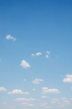 Soft blue sky with small white clouds