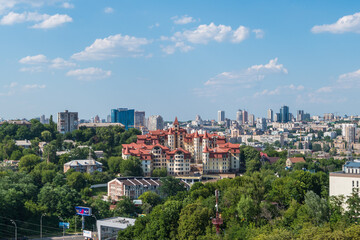 Cityscape featuring a modern urban skyline with lush greenery under a clear blue sky