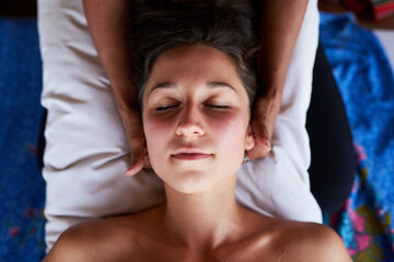 Woman, relax and eyes closed with head massage in spa above with masseuse for wellness with comfort...