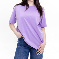 Woman in a long lilac T-shirt and blue jeans on white background. Square