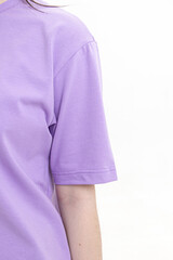 Young woman in cotton lilac T-shirt on white background. Sleeve closeup