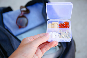 Clothes and pills in a travel bag.  Concept of medication required in journey.