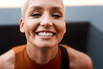 Happy woman, portrait and piercings with teeth, confidence or cheerful attitude in city. Female...