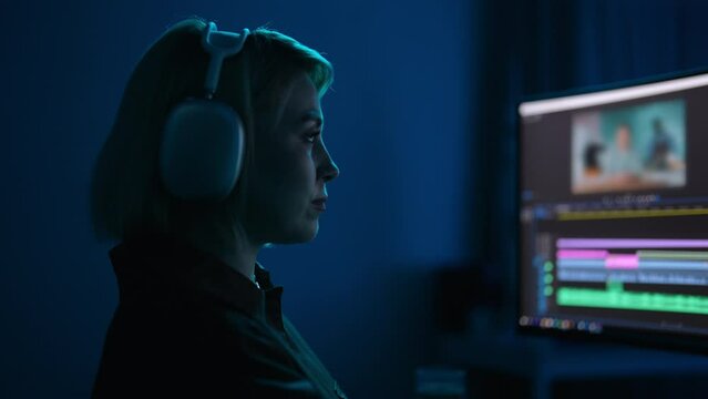Closeup face of focused graphic designer creating professional movie content with filmmaking software, timeline editing project. Attractive female cinematographer editing video footage, slow motion.