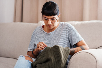 Woman, embroidery and hands on sofa for stitching sweater fabric with pattern and texture at home....