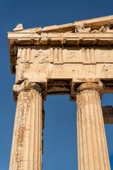 Fototapeta premium Upper part of an ancient Greek temple, The Parthenon. It features Doric columns and a pediment adorned with sculptural details