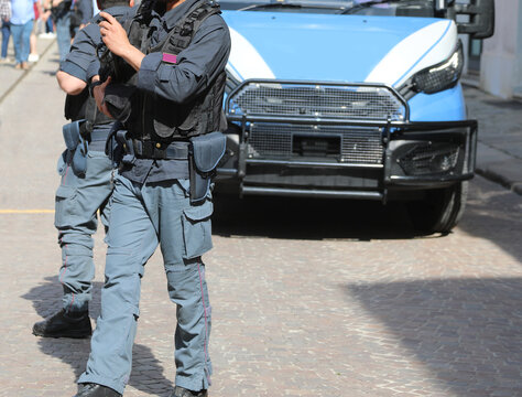 Riot police officer in riot gear with bulletproof vest during a protest demonstration in the city and an police van
