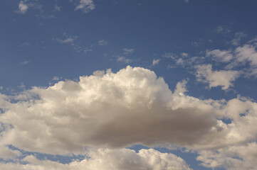 Large white cumulus cloud in a clear blue sky, summer day background