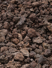 A pile of rocks is shown in a close up. The rocks are brown and appear to be small and rough. Concept of ruggedness and natural beauty