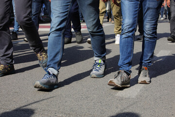 shoes and legs of men walking in the city during the peaceful protest demonstration