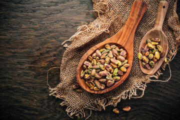 Roasted and peeled pistachios in wooden spoons