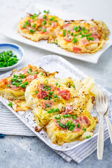 Oven baked cabbage steaks with parmesan, bacon and green onions