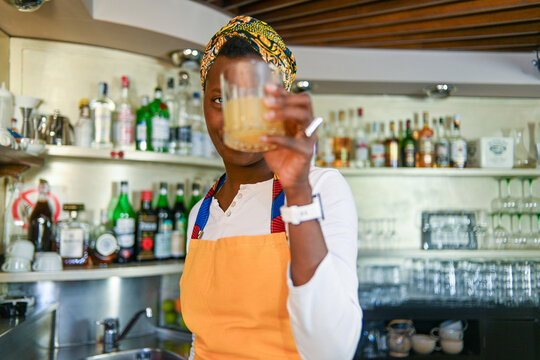 Professional african american female bartender in a vibrant headwrap and apron at work - Powered by Adobe