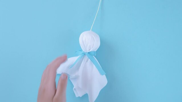 holding a little handmade doll called a teru teru bozu to wish for good weather tomorrow. てるてる坊主を持つ