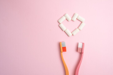 Toothbrush and chewing gum lie on a colored background. Time to brush your teeth. Top view, flat lay. Dental health concept