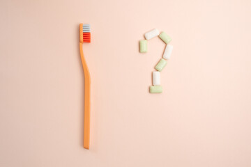 Toothbrush and chewing gum lie on a colored background. Time to brush your teeth. Top view, flat lay. Dental health concept
