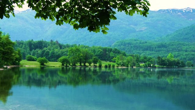 Rain on Bohinj lake beautiful green alpine mountain lake with crystal clear water in spring, Slovenia, Europe