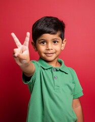 An indian 5 years smart student boy showing a victory sign with his hand