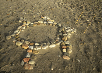 Drawing of a turtle made from pebbles on the beach of Chania