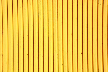 Yellow background of an old painted tin building wall