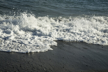 Sea wave with foam on the beach of Chania