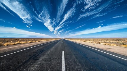 freedom ahead endless asphalt highway stretching towards bright blue sky with wispy clouds