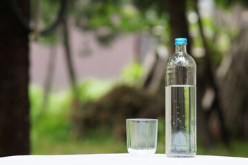 glass of water and bottle copy space selective focus on foreground, blurred background