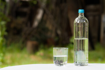 glass of water and bottle copy space selective focus on foreground, blurred background