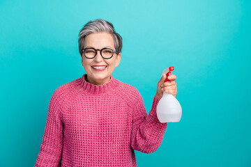 Photo of satisfied woman with short hair dressed pink sweater in glasses hold sprayer cleaning...