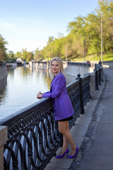 An elegant woman posing along the city embankment.