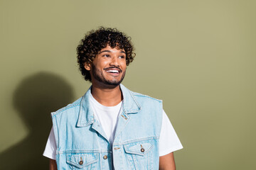 Photo portrait of handsome young guy look empty space wear trendy jeans outfit isolated on khaki...