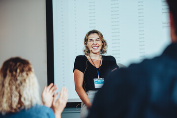 Businesswoman getting a round of applause after successful presentation