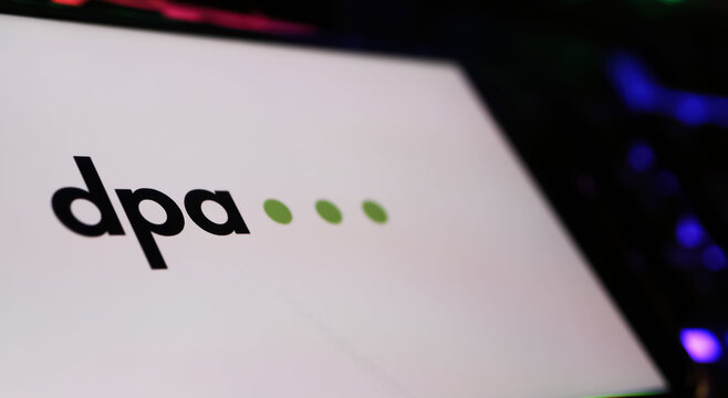 Viersen, Germany - May 9. 2024: Closeup of smartphone with logo lettering of DPA german press agency on computer keyboard