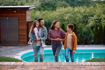 Cheerful parents and their kids enjoying in family day outdoors.