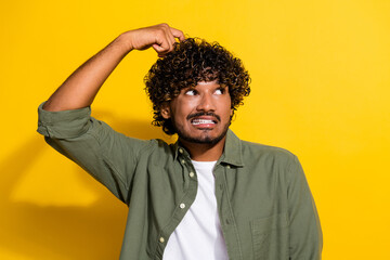 Portrait photo of young latin guy in khaki shirt nervous looking empty space scratch head guilty...