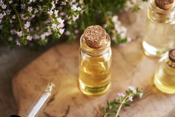 A bottle of aromatherapy essential oil with fresh blooming thyme twigs