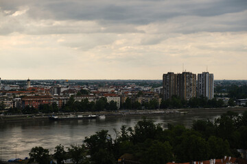 Obraz premium Serbia - Beautiful Panoramic view of Novi Sad and Danube River, spring cloudy evening. A bridge across the river for cars and pedestrians. View from Petrovaradin fortress.