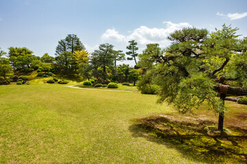 Green meadow with trees on the grounds of the medieval castle of Nijo, Kyoto.