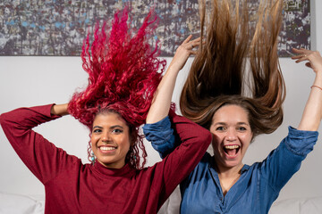 Mujeres amigas divirtiéndose lanzando su cabello hacia arriba