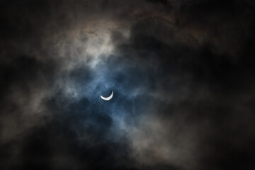 Near total eclipse of the Sun. The moon covers the sun in a solar eclipse and cloudy dramatic sky....