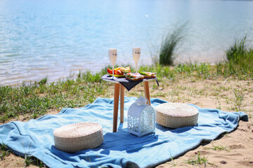 Obraz premium leisure and drinks concept - close up of food, drinks and basket on picnic blanket on grass
