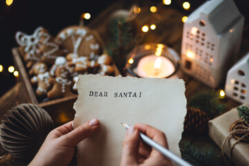 Christmas letter on craft paper to Santa Claus with text: Dear Santa. Cozy home interior with...