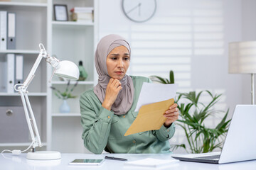 Sad and unhappy business woman in hijab reading mail letter, upset muslim woman received bad news...