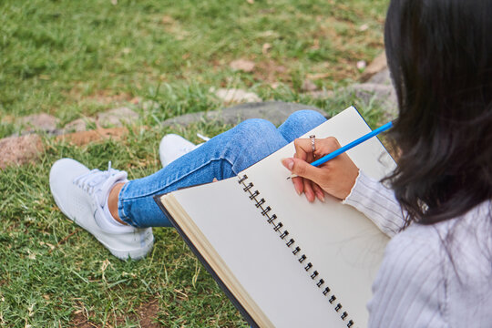 Woman Writing in a Notebook Outdoors