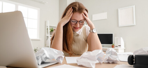 Stressed young businesswoman working under deadline in office